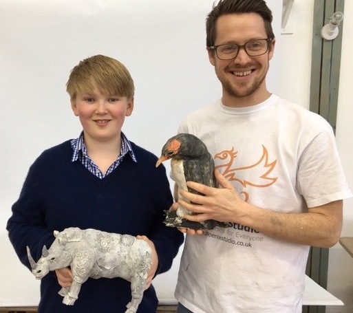 Young artist with his artwork and James, the tutor